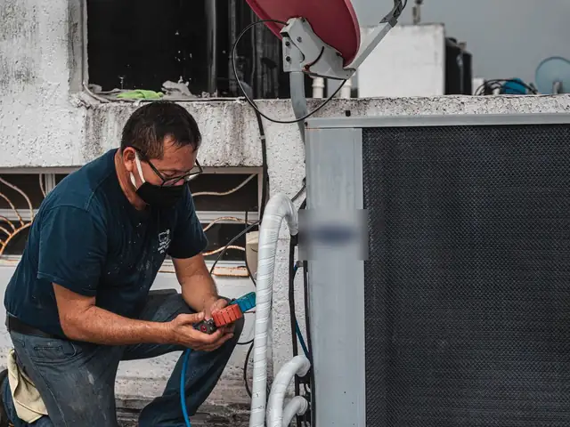 Technician servicing an outdoor HVAC unit during a seasonal tune-up